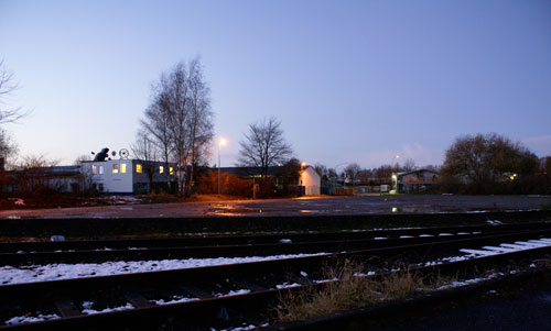 Um diesen Parkplatz (noch liegt er friedlich in der Abenddämmerung) geht es Parkplatz